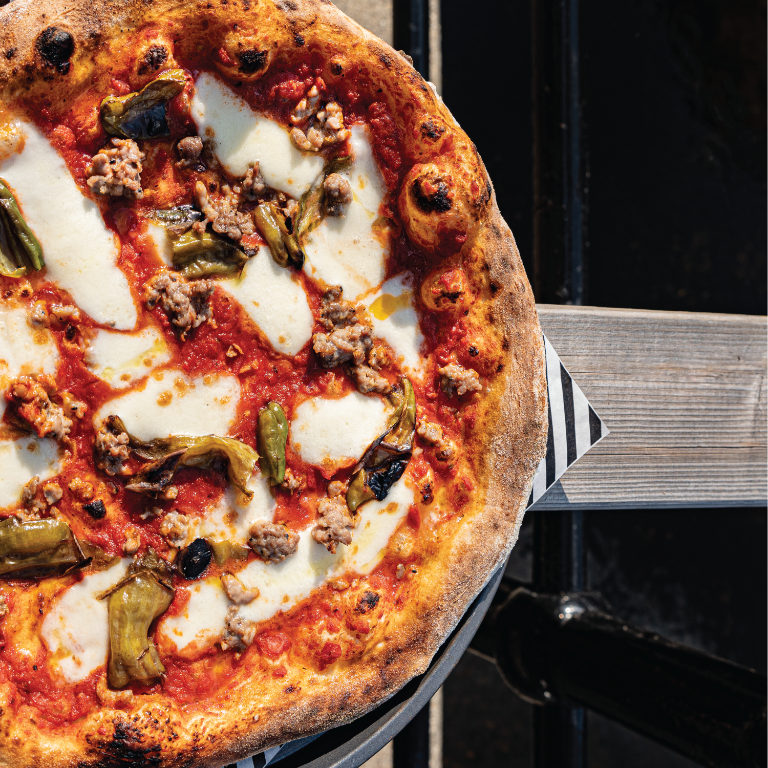 Personal-sized pizza with toppings on a wooden table